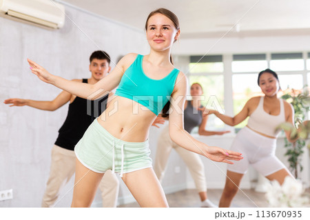 Girl teen perform choreographic exercise and teach energetic mobile social dance groove with friends 113670935