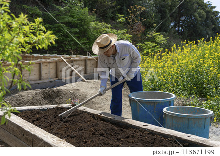 晴れた日に楽しそうに土を耕す男性 113671199