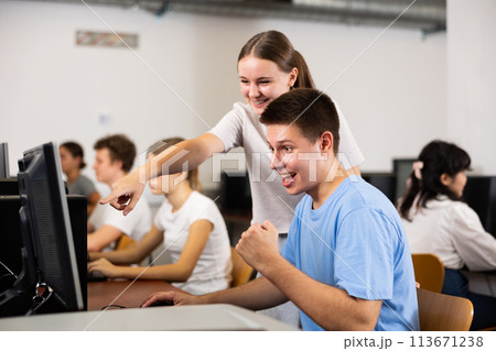 Positive toung boy and girl playing videogame in computer class Positive toung boy and girl playing videogame in computer class 113671238