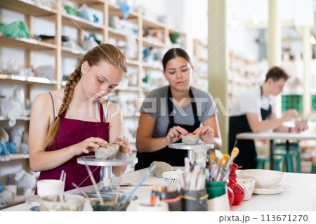 Teenage girl sculpts ceramic product in ceramic workshop Teenage girl sculpts ceramic product in ceramic workshop 113671270