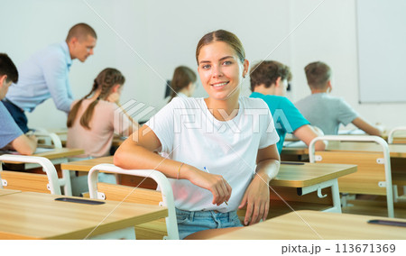 Young girl sitting at desk in class room 113671369