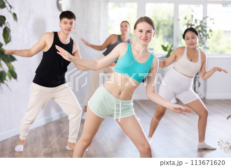 Happy young girl practicing dance positions during workout session Happy young girl practicing dance positions during workout session 113671620