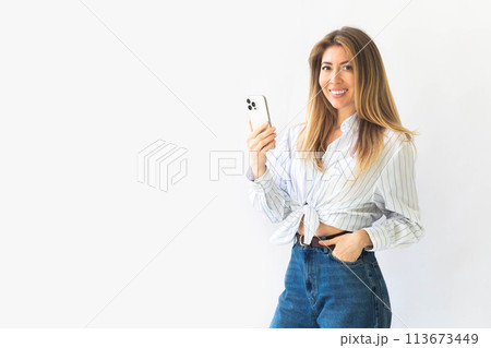 Caucasian businesswoman in formal attire in her office happy using smartphones and working Caucasian businesswoman in formal attire in her office happy using smartphones and working 113673449