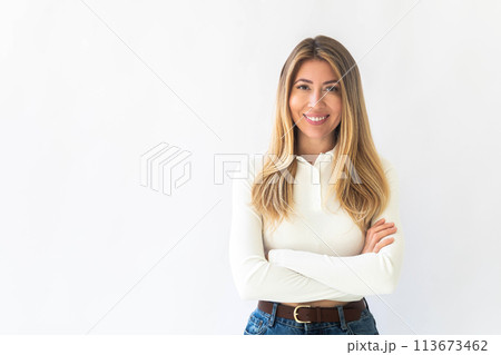 Portrait of a young Caucasian woman with pleasant smile and crossed arms isolated on white wall 113673462