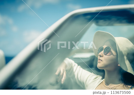 オープンカーの窓から海を眺める女性 113673500