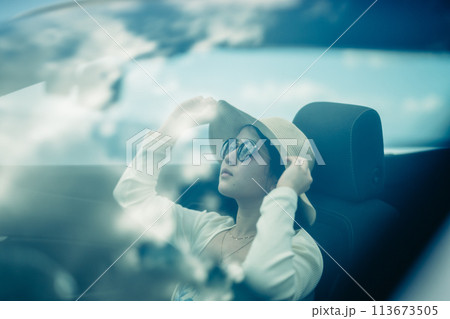 オープンカーの窓から海を眺める女性 113673505