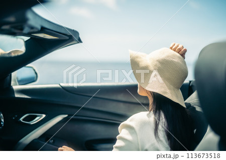 オープンカーの窓から海を眺める女性 113673518