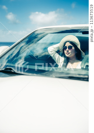 オープンカーの窓から海を眺める女性 113673519