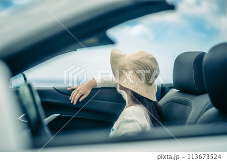 オープンカーの窓から海を眺める女性 113673524