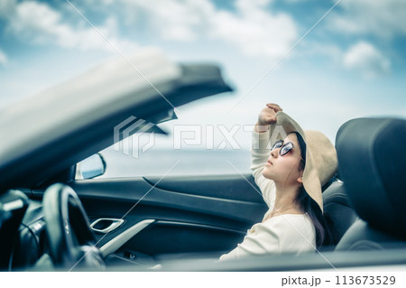 オープンカーの窓から海を眺める女性 113673529