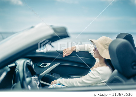 オープンカーの窓から海を眺める女性 113673530