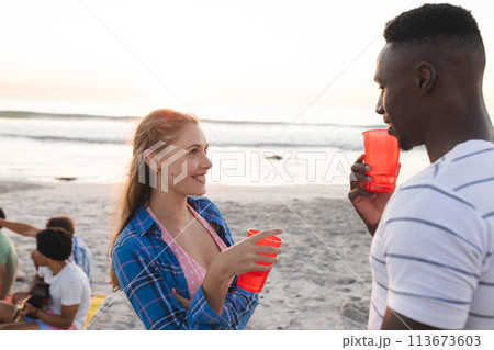 Young Caucasian woman and African American man enjoy a beach party Young Caucasian woman and African American man enjoy a beach party 113673603