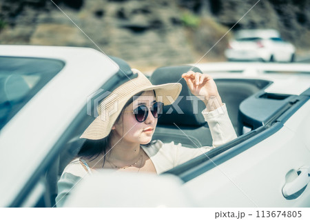 オープンカーの窓から海を眺める女性 113674805