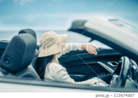 オープンカーの窓から海を眺める女性 113674807