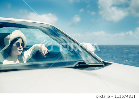 オープンカーの窓から海を眺める女性 113674811