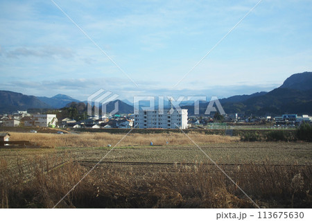 Landscapes of the countryside in Japan Showing a rice field after harvest, with a mountain view in the early winter. Landscapes of the countryside in Japan Showing a rice field after harvest, with a mountain view in the early winter. 113675630