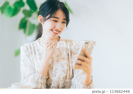 リビングでスマホを見る女性 113682449