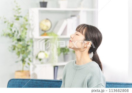 リビングで目を閉じる女性 113682808