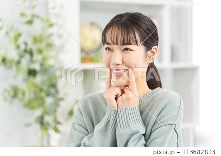 リビングで笑顔の練習をする女性 113682813