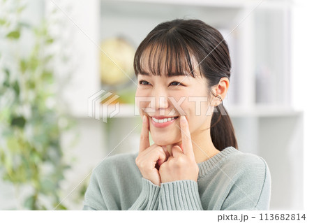 リビングで笑顔の練習をする女性 113682814