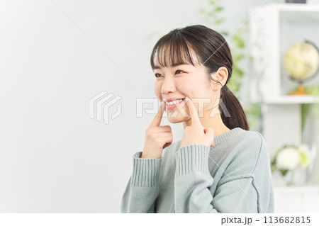 リビングで笑顔の練習をする女性 113682815