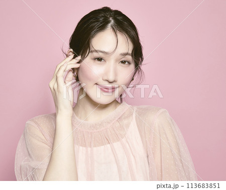 ピンク背景で撮影した若い華やかな女性のポートレート ピンク背景で撮影した若い華やかな女性のポートレート 113683851