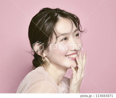 ピンク背景で撮影した若い華やかな女性のポートレート 113683871