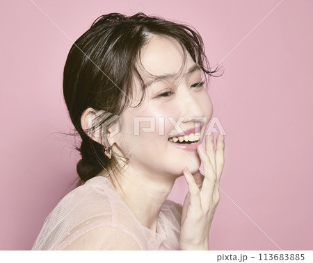 ピンク背景で撮影した若い華やかな女性のポートレート 113683885