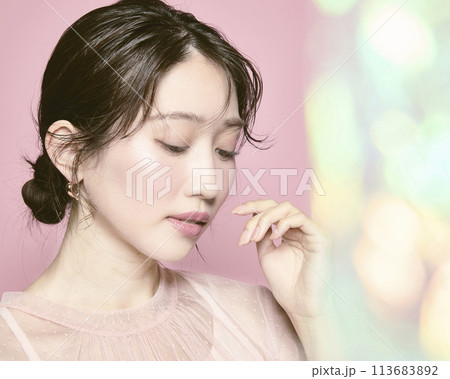 ピンク背景で撮影した若い華やかな女性のポートレート 113683892