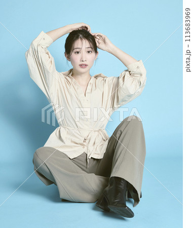 青背景で撮影した若い女性のポートレート 113683969