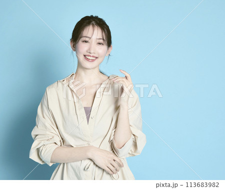 青背景で撮影した若い女性のポートレート 113683982
