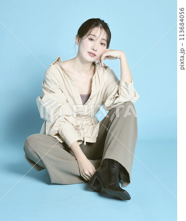 青背景で撮影した若い女性のポートレート 113684056