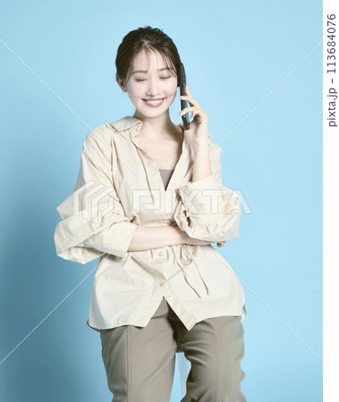 青背景で撮影したスマホとバッグを持った若い女性 青背景で撮影したスマホとバッグを持った若い女性 113684076