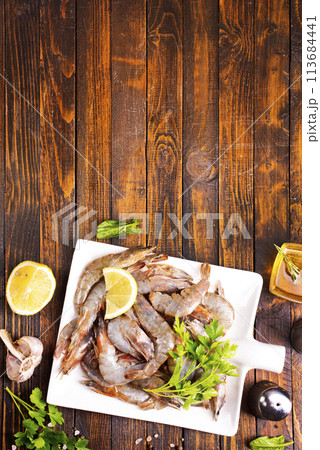Uncooked Raw peeled tiger white shrimp prawn. wooden background. 113684441