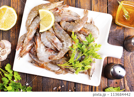 Uncooked Raw peeled tiger white shrimp prawn. wooden background. 113684442