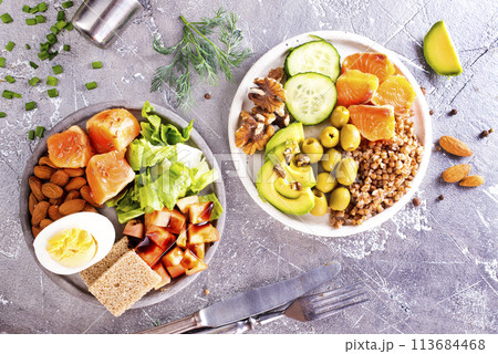 salad with salmon, boiled egg, bean, tomato, salad and almond nuts. 113684468