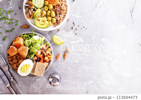 salad with salmon, boiled egg, bean, tomato, salad and almond nuts. 113684473