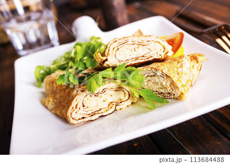Dashimaki tamago, Japanese style rolled omelette in dish on wooden table Dashimaki tamago, Japanese style rolled omelette in dish on wooden table 113684488