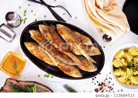 fried fish in pan on a table 113684513