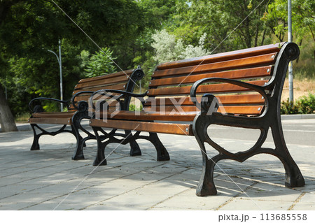 Beautiful wooden benches stand on the street 113685558