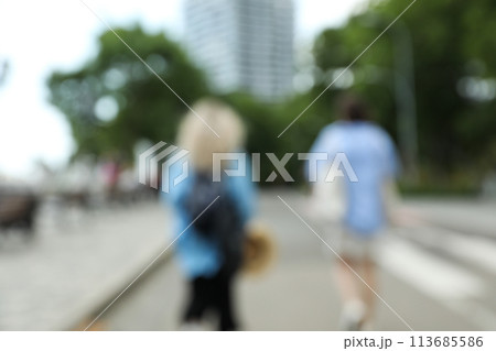 Blurred city photo with trees and people 113685586