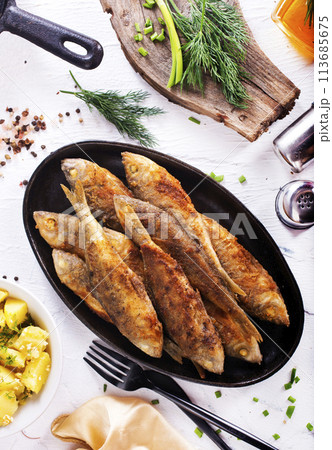 fried fish in pan on a table 113685675