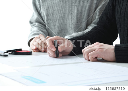 契約を交わす夫婦の手元 113687210