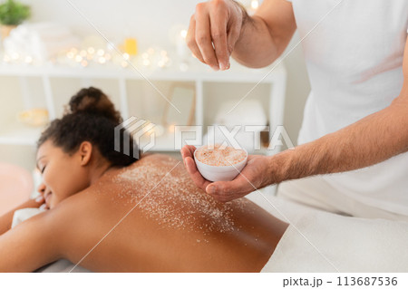 Applying exfoliating scrub during spa treatment at spa Applying exfoliating scrub during spa treatment at spa 113687536