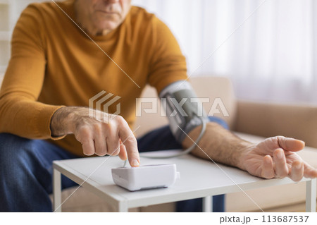 Man measuring blood pressure with digital monitor 113687537