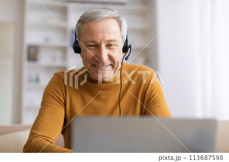 Elderly man enjoying music on headphones 113687598
