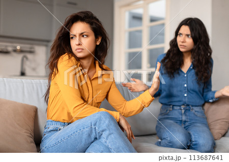 Tense discussion between two girlfriends at home Tense discussion between two girlfriends at home 113687641