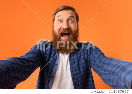 Excited Man With Red Beard Shouting Spreading Hands, Orange Background 113687697