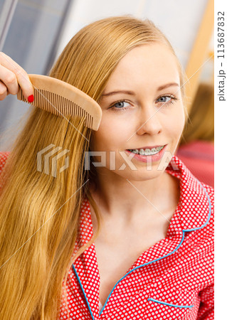 Woman combing her long hair in bathroom Woman combing her long hair in bathroom 113687832