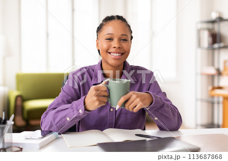 Student enjoying cup of coffee while studying at home 113687868